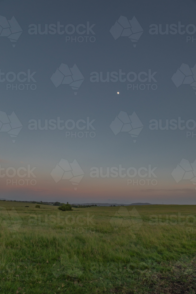 A dawn sky in the country under a setting full moon - Australian Stock Image