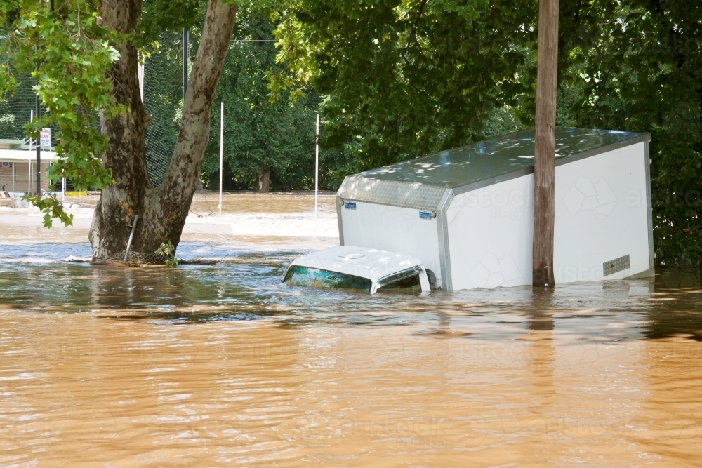 A delivery truck half submerged in flood waters - Australian Stock Image