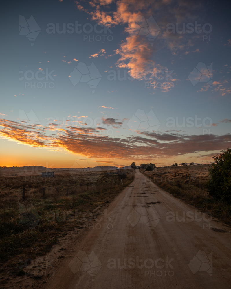 A dirt country road in the country under a colourful dawn sky - Australian Stock Image