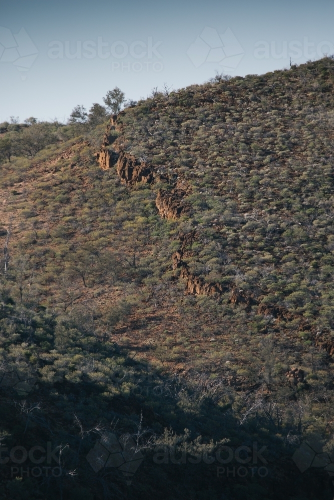A distinct rocky ridge line running down a hill - Australian Stock Image
