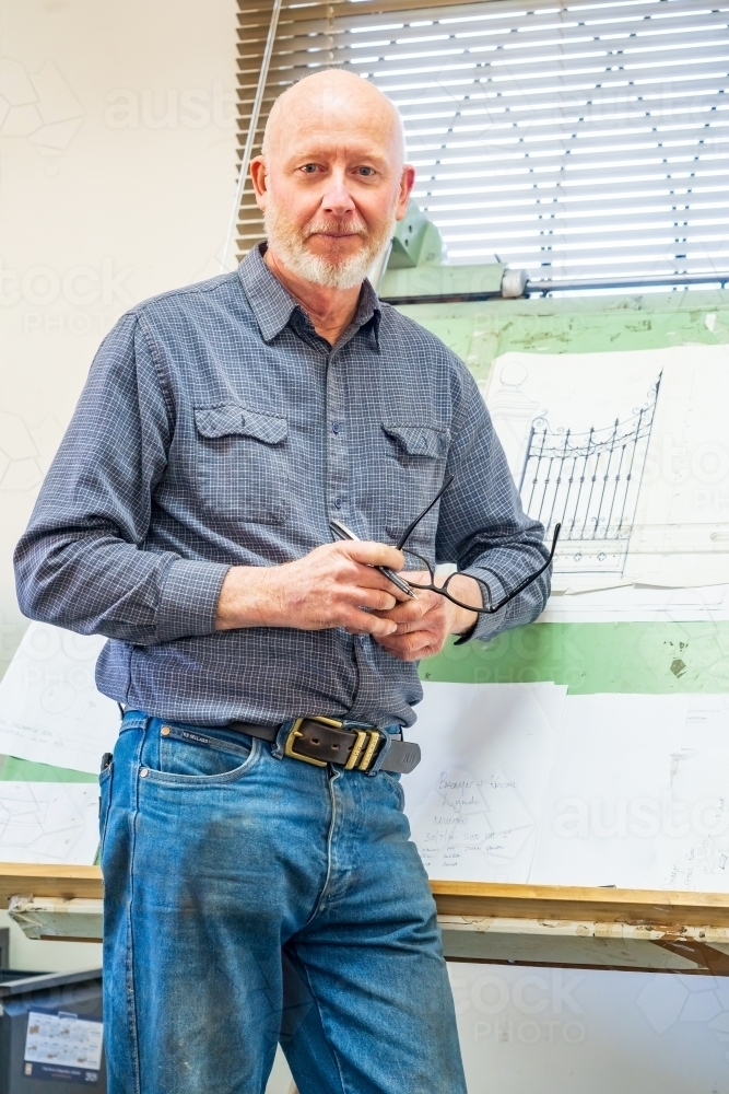 A draftsman standing proudly in front of his drawing board - Australian Stock Image