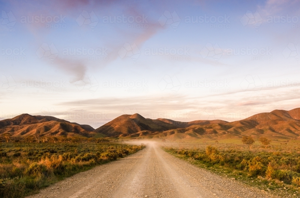 A dusty track leading to the Flinders Ranges at sunset - Australian Stock Image