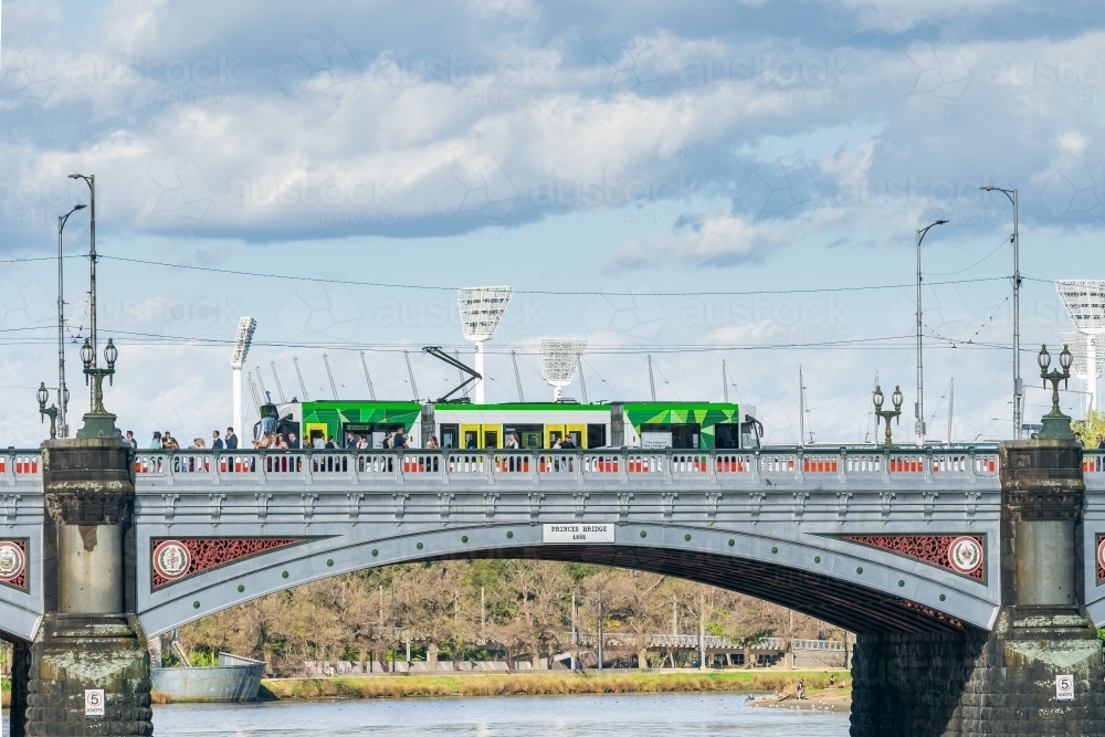 A electric commuter tram going over an historic arched bridge - Australian Stock Image