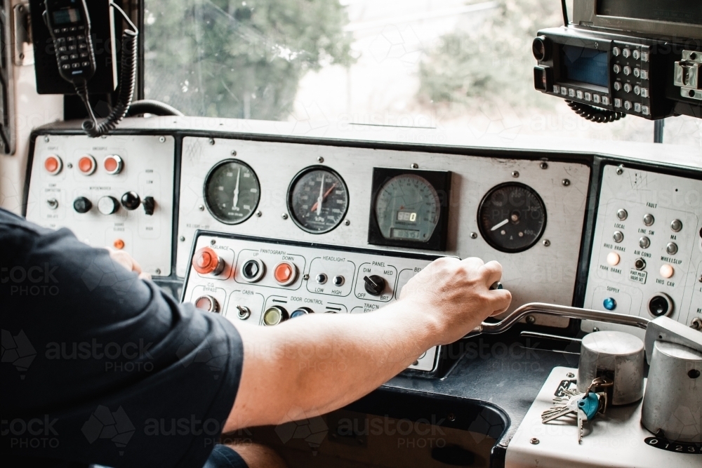 A electric train in Melbourne Australia, inside controls being driven by a train driver - Australian Stock Image