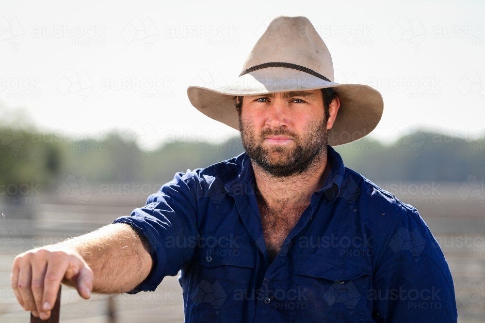 A farmer leans on an iron post during the drought - Australian Stock Image