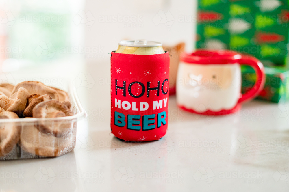 A festive scene features colourful decorations, gifts, and a playful beer can - Australian Stock Image