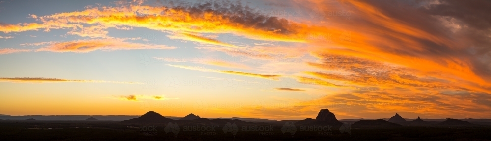 A fiery sunset over the volcanic plug Glasshouse Mountains, Sunshine Coast. - Australian Stock Image