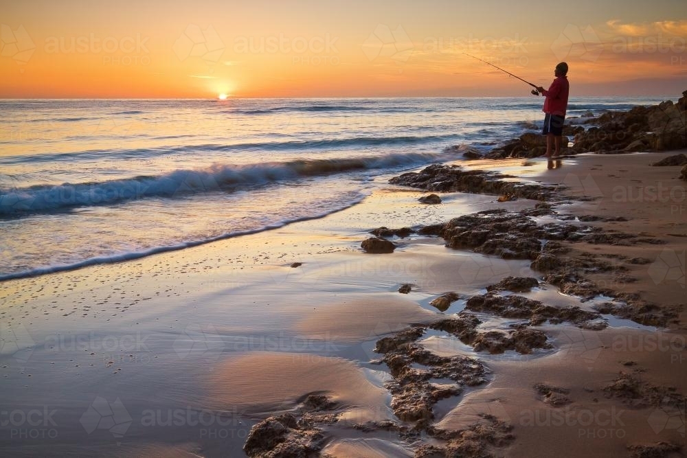 A fisherman on the coast at sunrise - Australian Stock Image