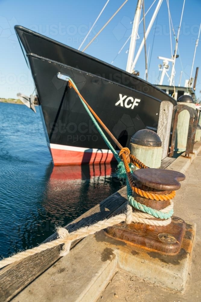 A fishing boat tied up to a wharf - Australian Stock Image