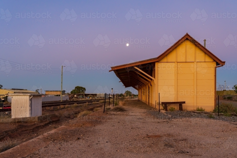 A full moon rising at twilight over an abandoned railway station - Australian Stock Image