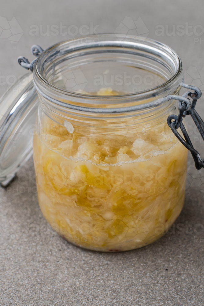 a glass jar has fermenting sauerkraut, day 10, bubbles on visible on the surface - Australian Stock Image
