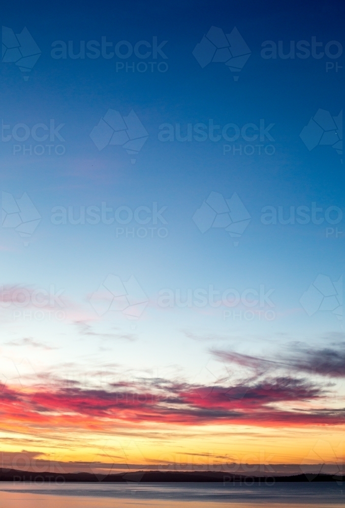 A golden sunset falls over the bay and distant peninsula - Australian Stock Image