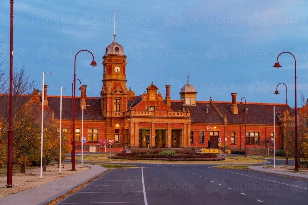 A grand old railway station with a clock tower at twilight - Australian Stock Image