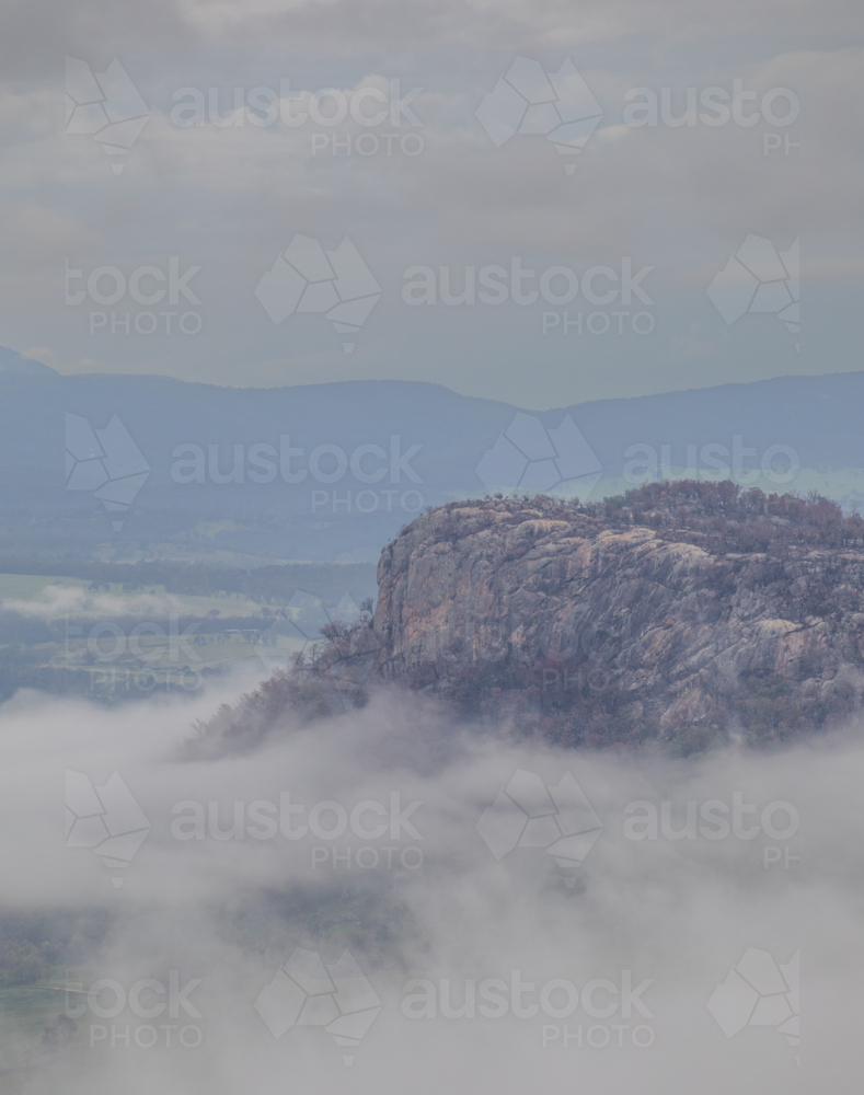 A granite monolith on a misty morning in the country - Australian Stock Image