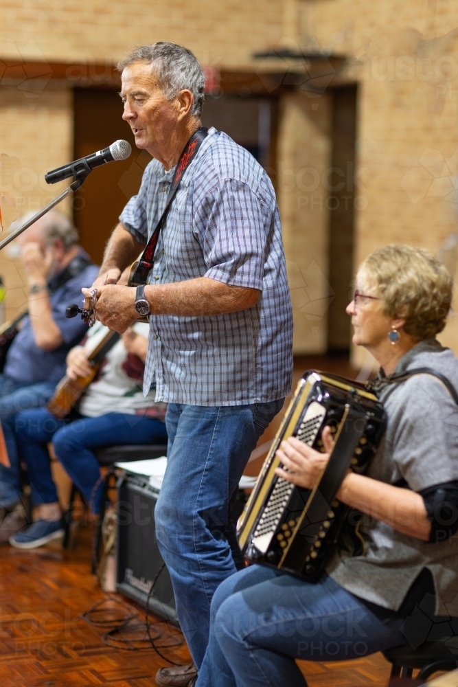 a group of older musicians singing and playing music - Australian Stock Image