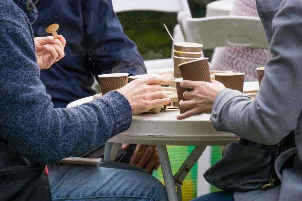 A group of people eating from paper cups - Australian Stock Image