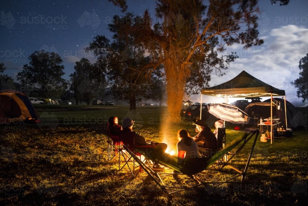 A group of people sitting around a campfire - Australian Stock Image