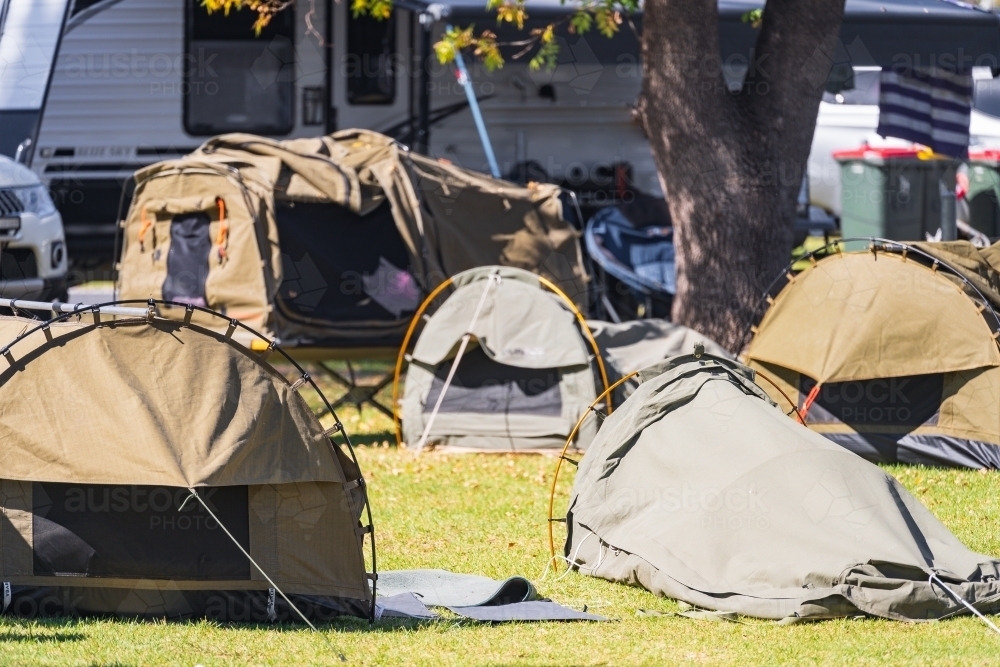 A group of sleeping swags set up on a grassy area of a campground - Australian Stock Image