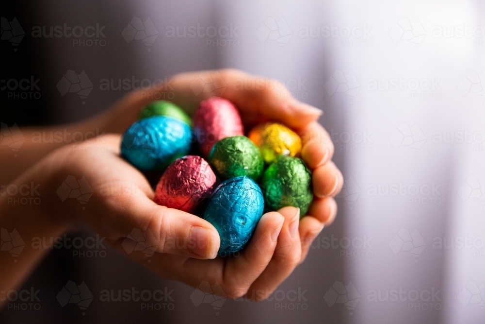 a heap of Easter eggs being held in hands - Australian Stock Image
