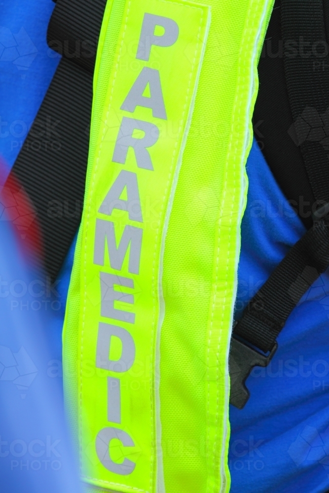 A high-vis paramedic life vest being worn over a blue uniform - Australian Stock Image