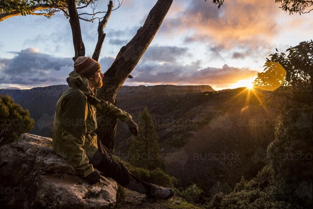 A hiker watching the sunset beside the Overland Track - Australian Stock Image