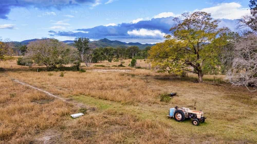 A horizontal shot of a big field with a tractor driving by - Australian Stock Image