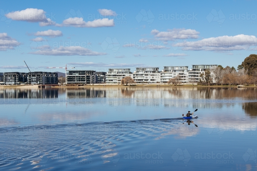 A kayaker glides across Lake Burley Griffin in Canberra - Australian Stock Image