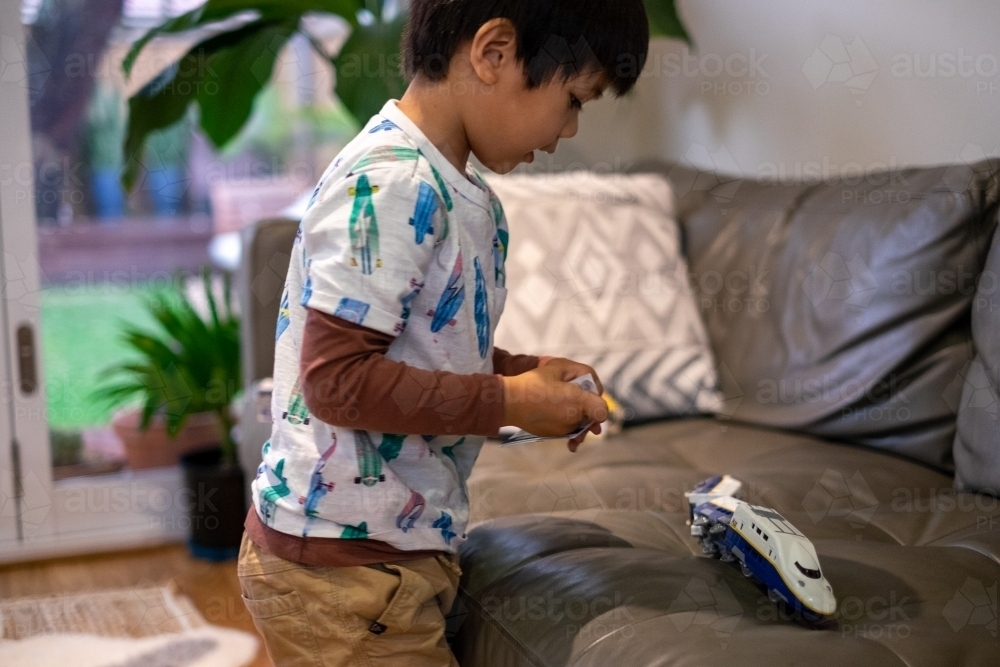 a kid playing with his toy train - Australian Stock Image