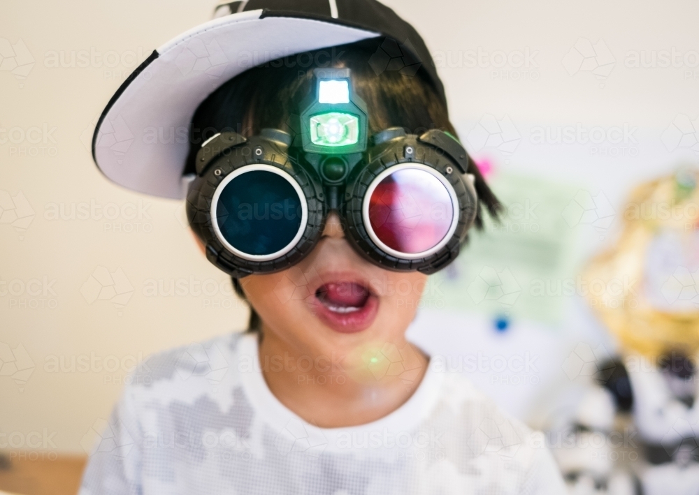 a kid wearing his new toy goggles during playtime - Australian Stock Image