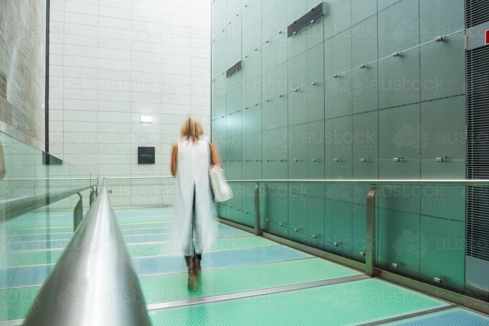 A lady walking through a gallery corridor - Australian Stock Image