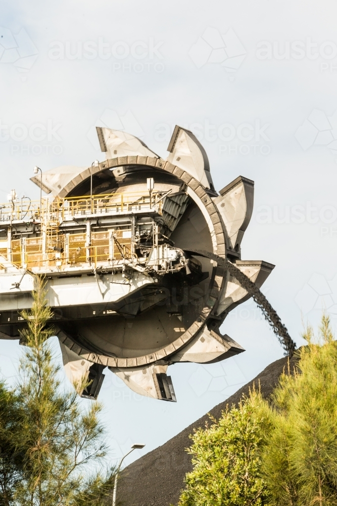 A large continuous miner machine seen through the treetops. - Australian Stock Image