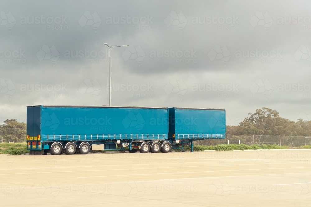 A large covered in truck trailer sitting at a truckstop - Australian Stock Image