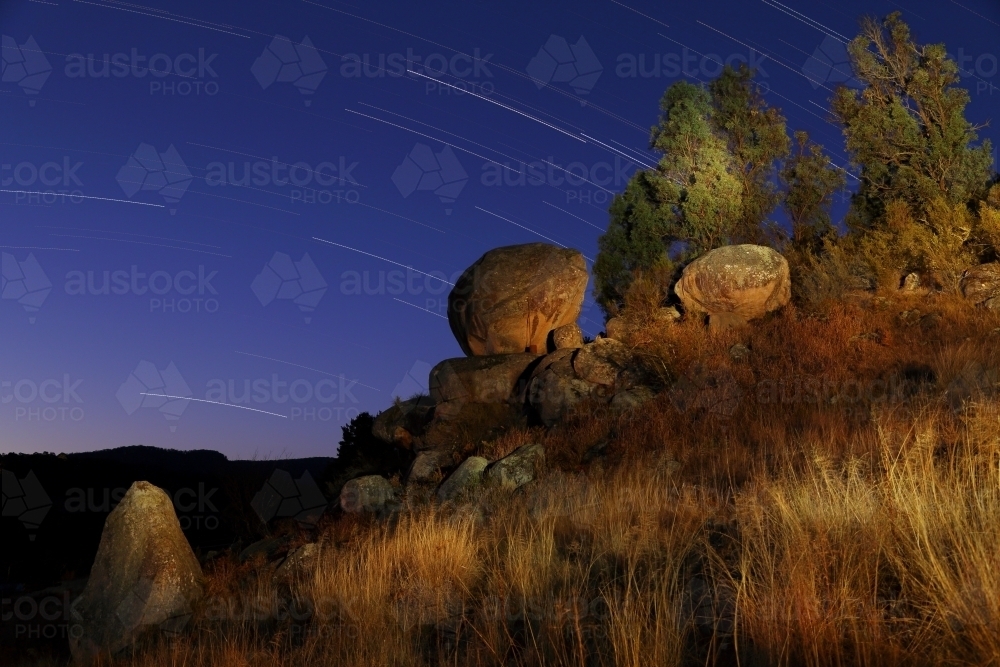 A light painting of the granite rock feature "The Tor" with star trails, at Hartley, NSW - Australian Stock Image