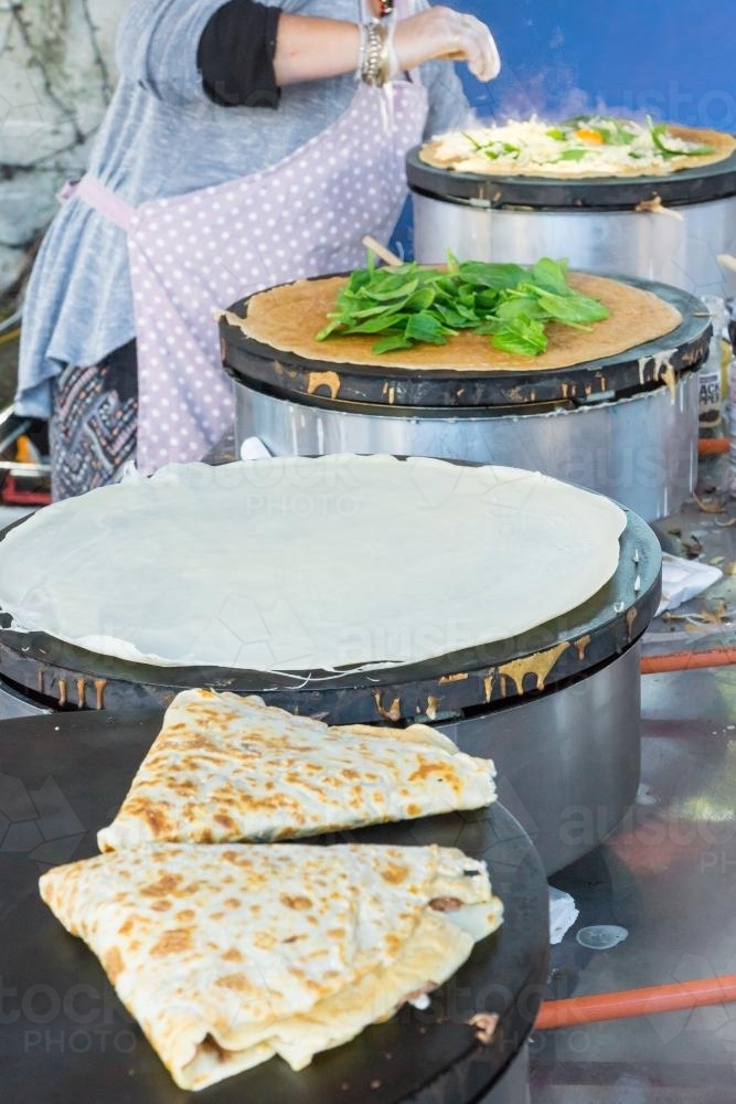 A line of hotplates with asian style wraps being cooked - Australian Stock Image