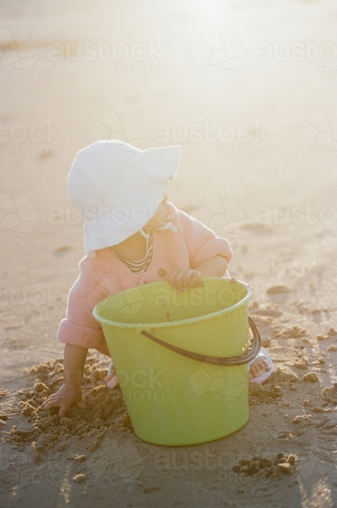 A Little Toddler Playing with Sand at the Beach - Australian Stock Image