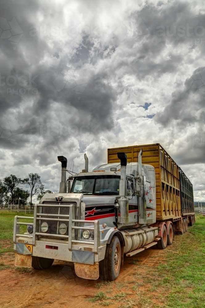 A livestock B-Double semi-trailer truck under a stormy rural sky - Australian Stock Image