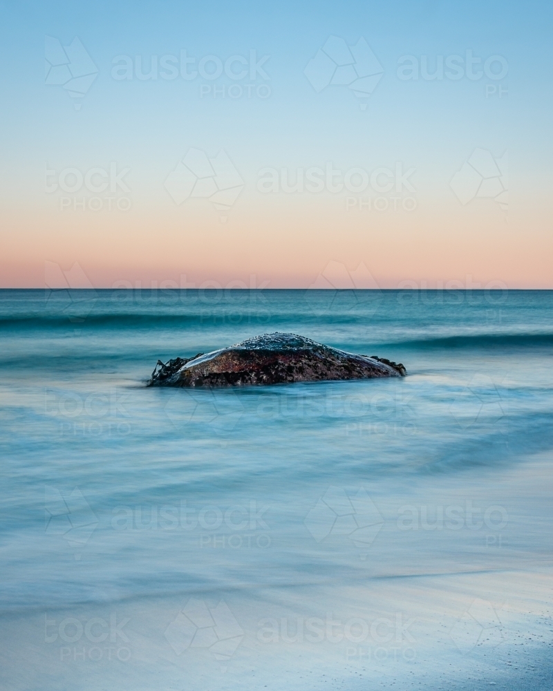 A Lone Rock Surrounded by a Pastel Sunset. - Australian Stock Image