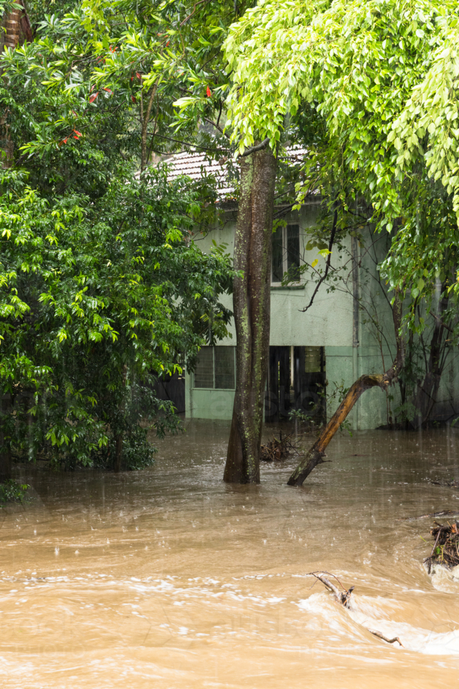 A low lying house adjacent to a creek in Ashgrove flooded underneath - Australian Stock Image