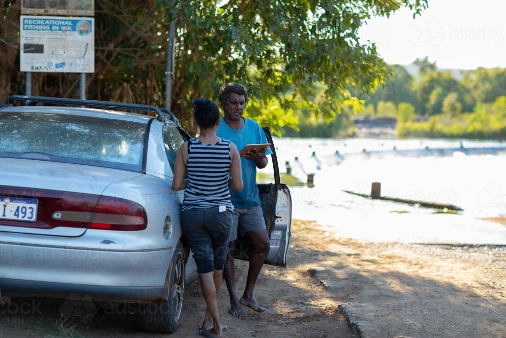a man and a woman near a car near river crossing - Australian Stock Image