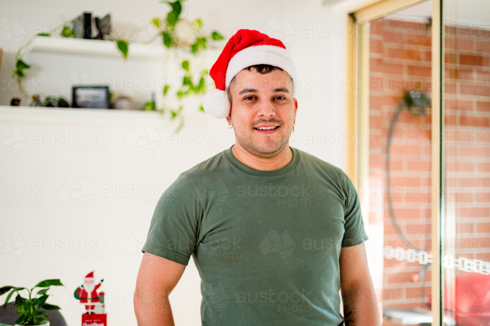 Image of A man in a Santa hat enjoys the holiday spirit with Christmas ...