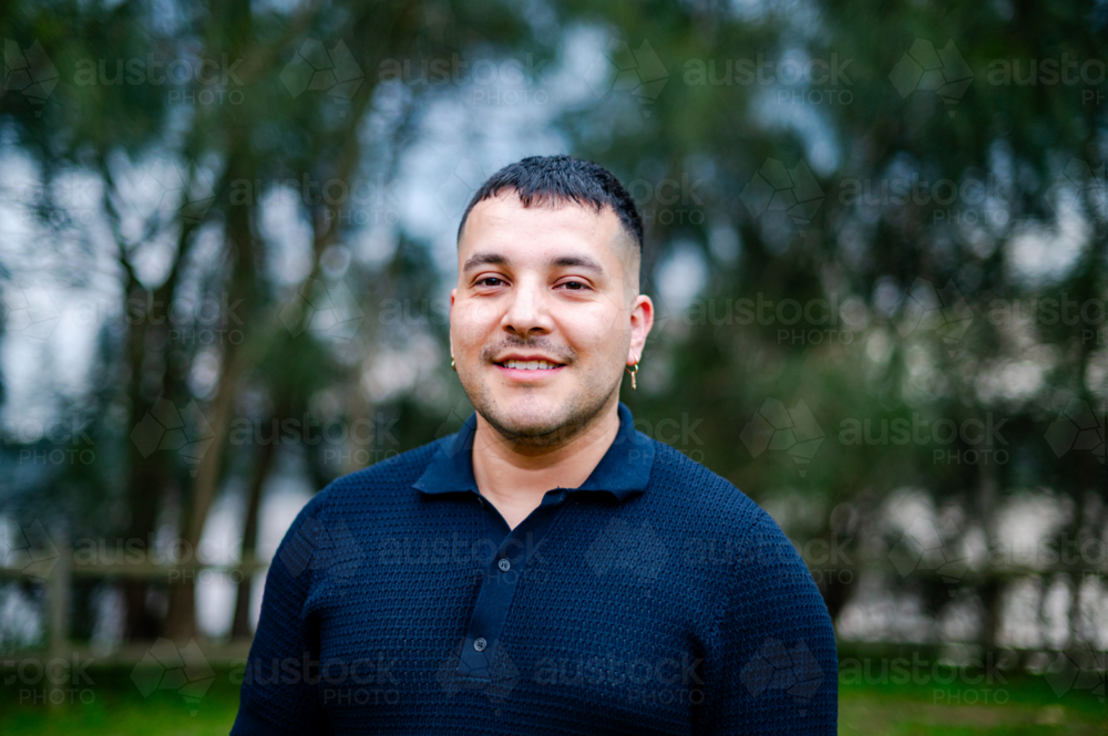 Image of A man in his 30s stands in a park, smiling brightly while ...