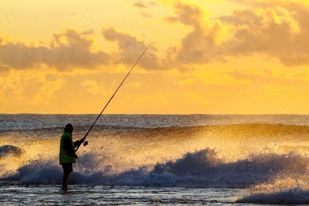 A man in his forties rock fishing at Wombarra Headland on the Illawarra Coast, NSW - Australian Stock Image