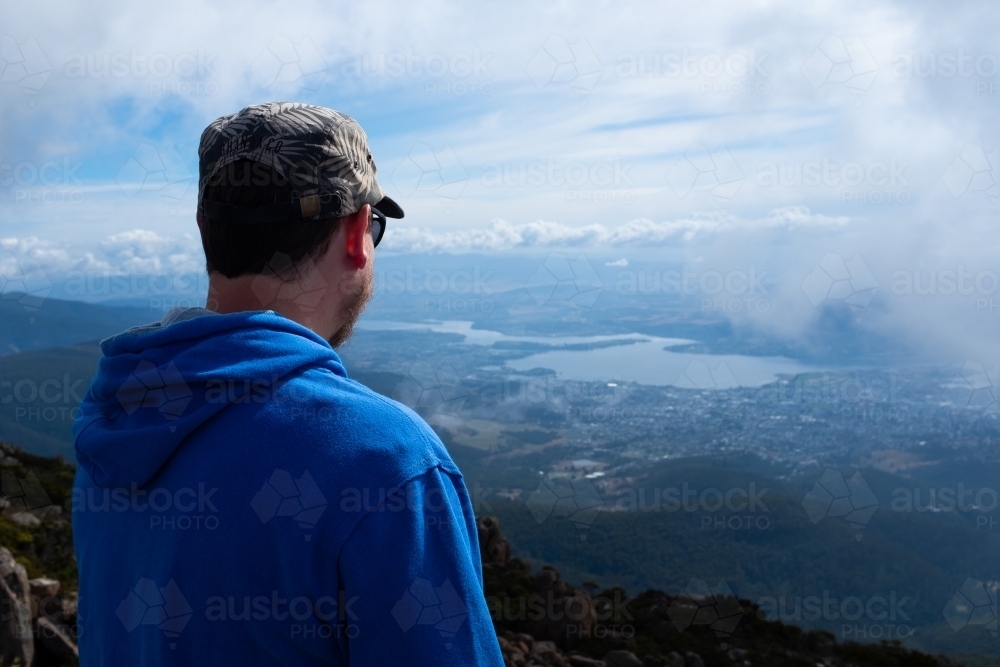 A man looking at Hobart from Mount Wellington in Tasmania - Australian Stock Image