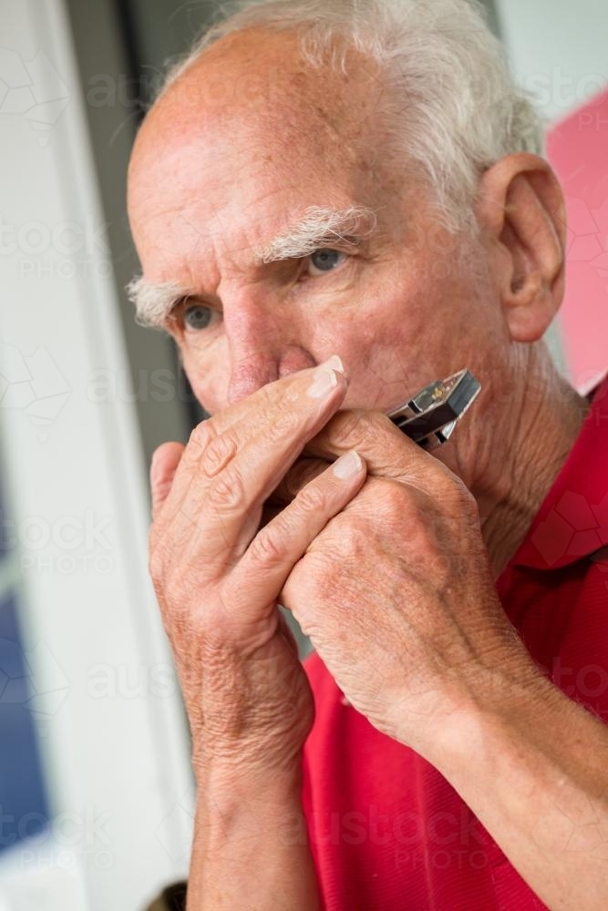 A man playing a harmonica - Australian Stock Image