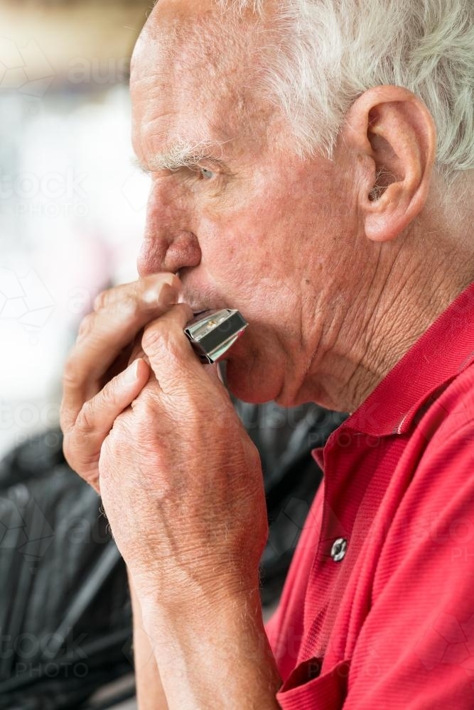 A man playing a harmonica - Australian Stock Image