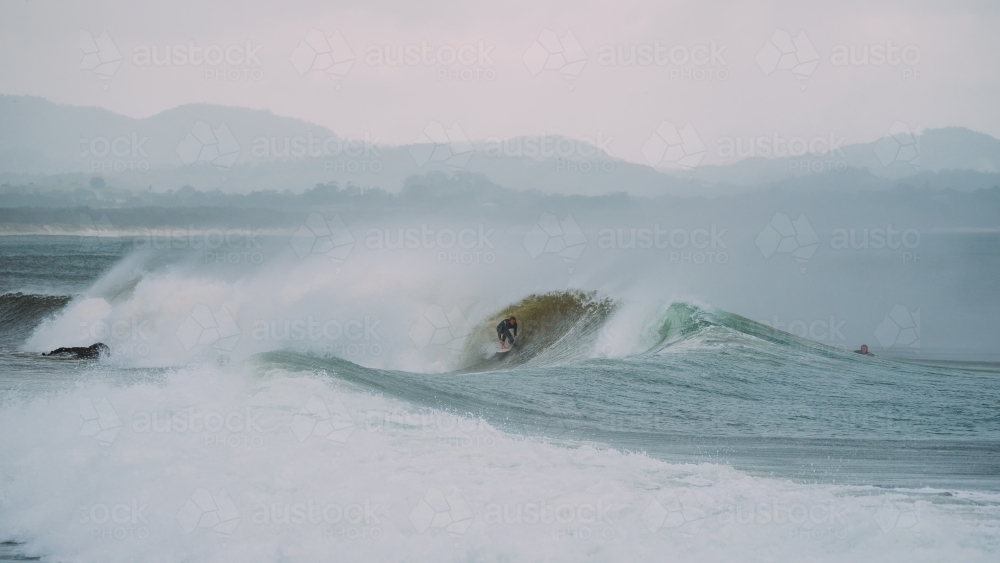 A man surfing in a barrel - Australian Stock Image