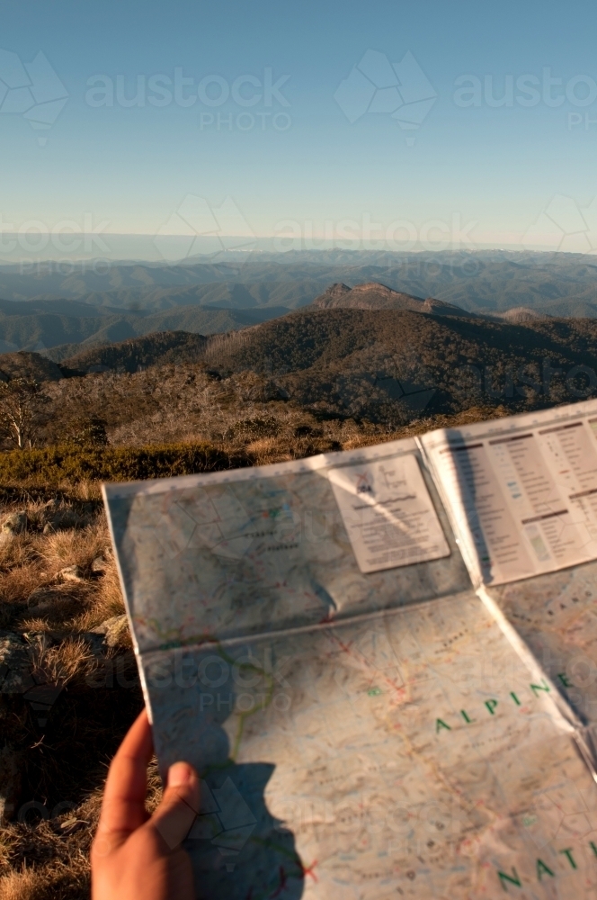 A map being held with mountain ranges in the background. - Australian Stock Image