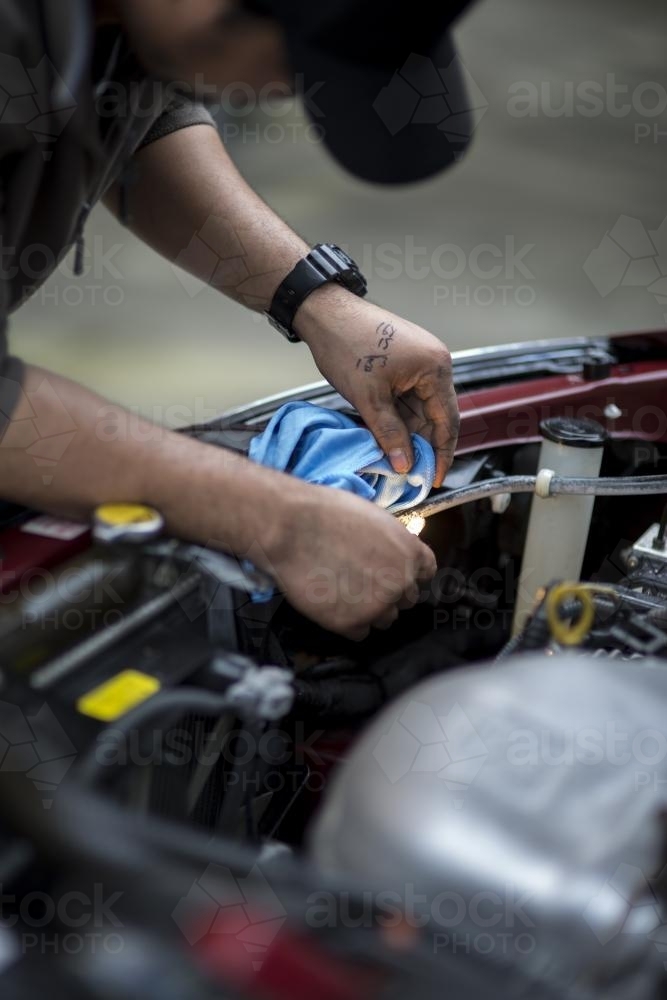A mechanic inspects a headlight. - Australian Stock Image