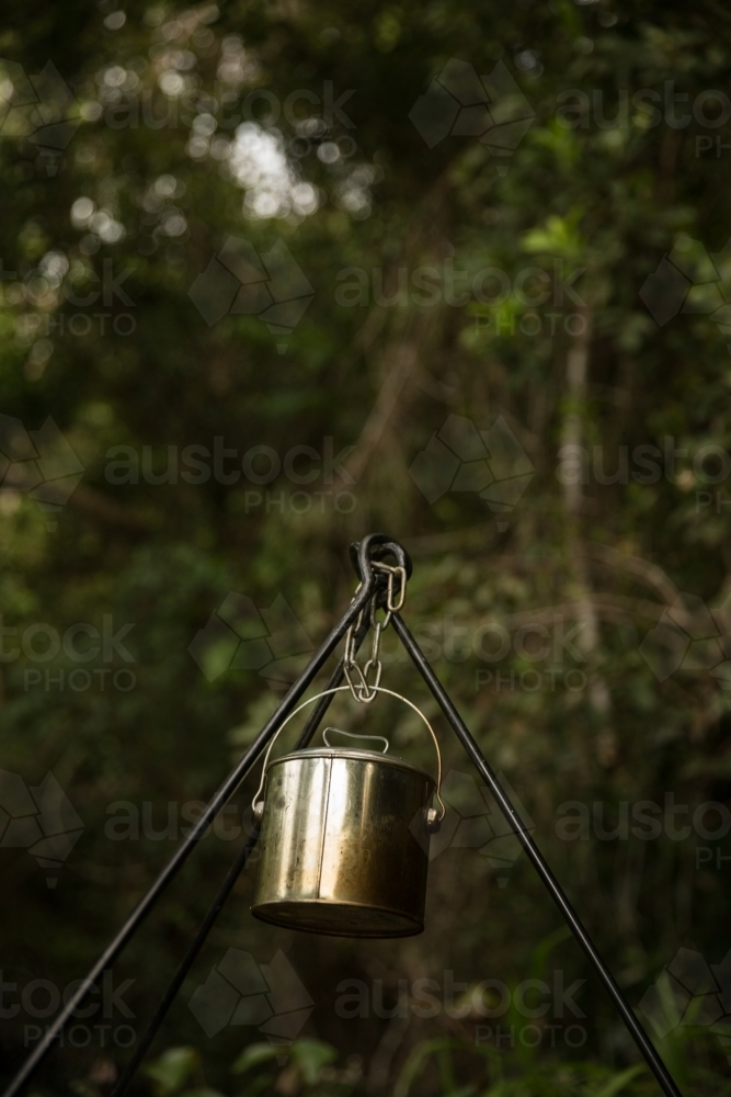 A metal camping pot hanging on a tripod. - Australian Stock Image