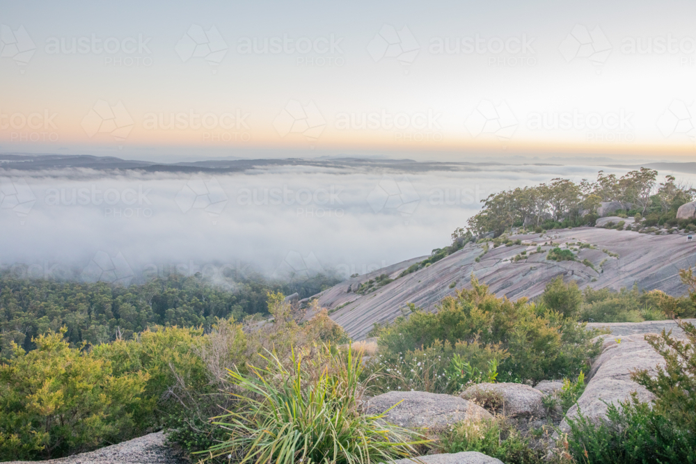 A misty morning sunrise on a granite monolith - Australian Stock Image